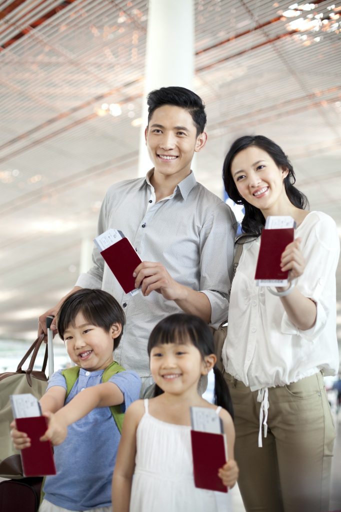 Happy family with flight tickets and passports at the airport